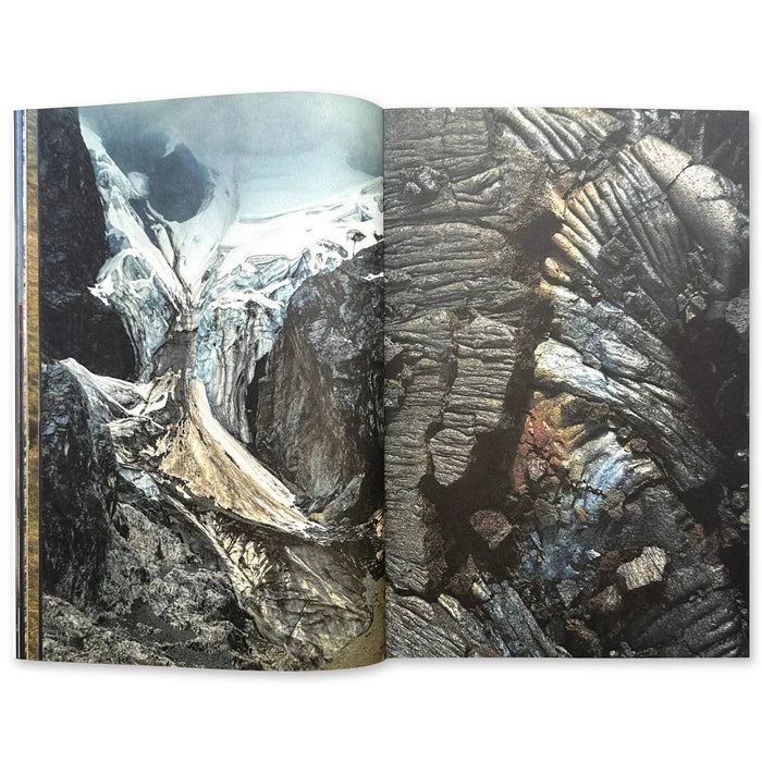 An open book displays an aerial landscape photo of a glacier next to a field of dark textured volcanic rock