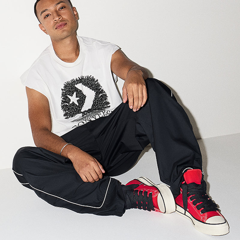 Men's red high-top sneakers worn with black pants and white sole