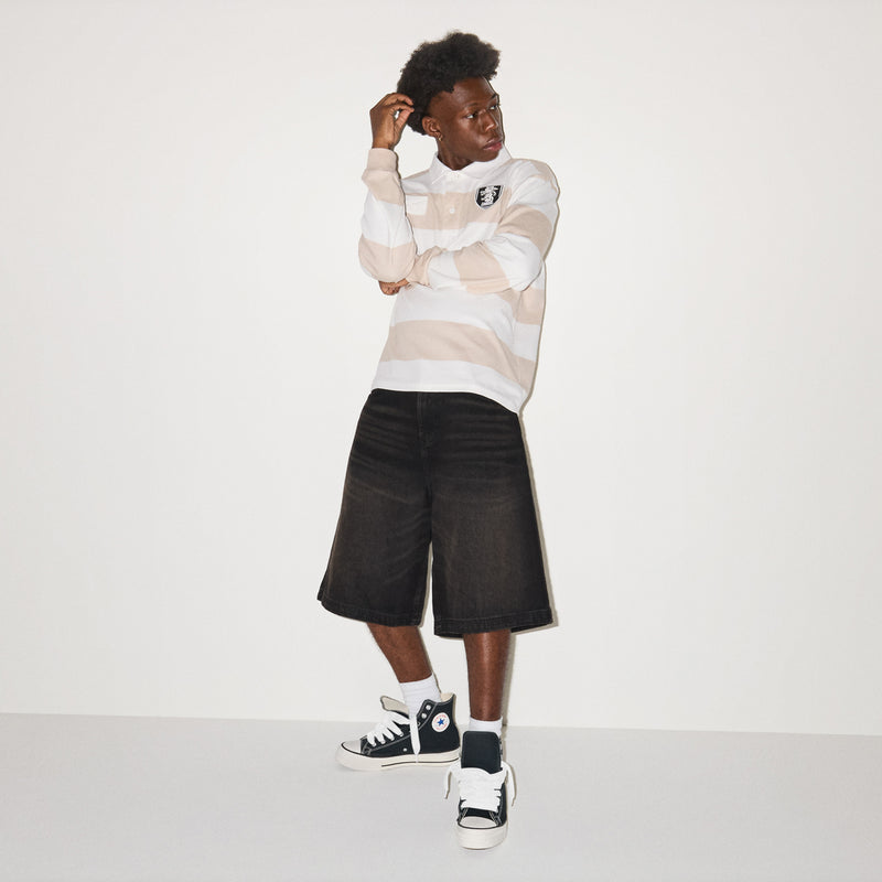 Men’s high-top sneakers on model: black canvas, white laces, white rubber sole