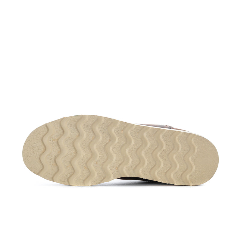 Underside of brown ankle chelsea boot outsole with light textured tread