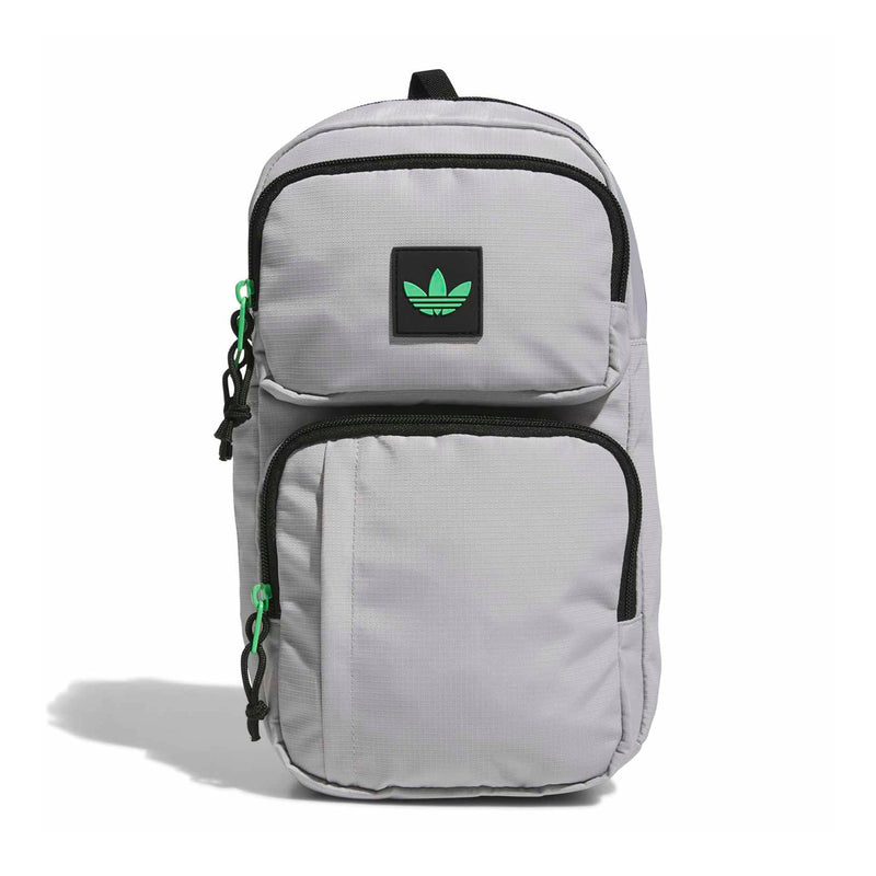 Light grey sling bag with black trim, green pull tabs, front patch logo, top handle