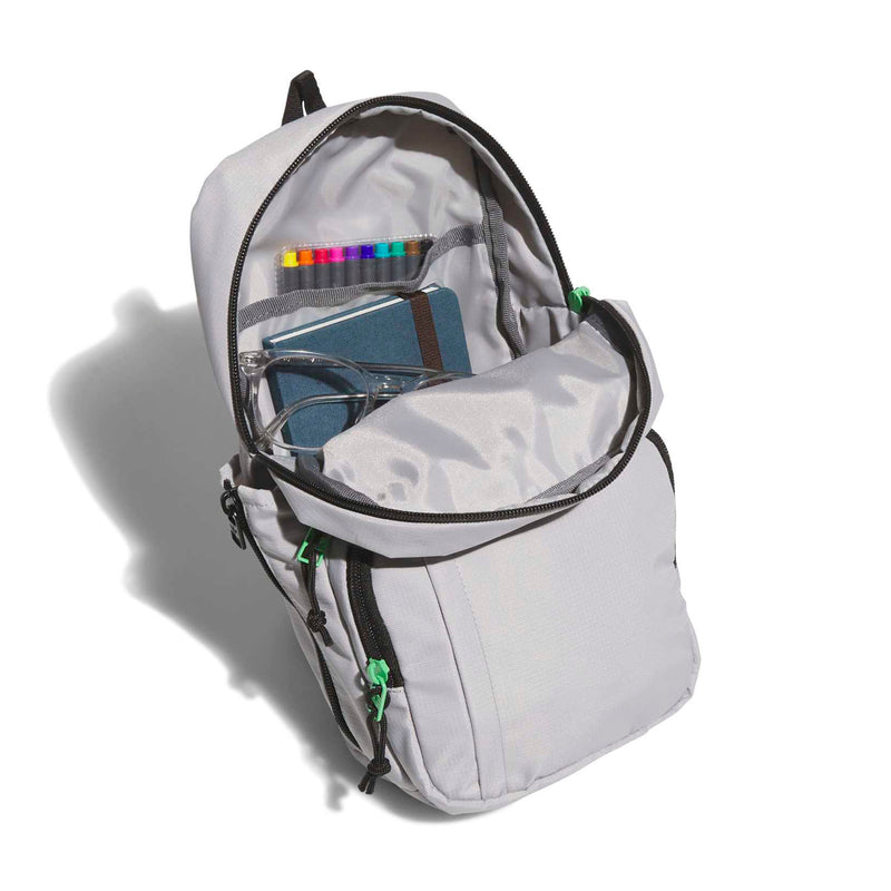Light grey sling bag opened to interior pocket; black zipper, green accents, side loops