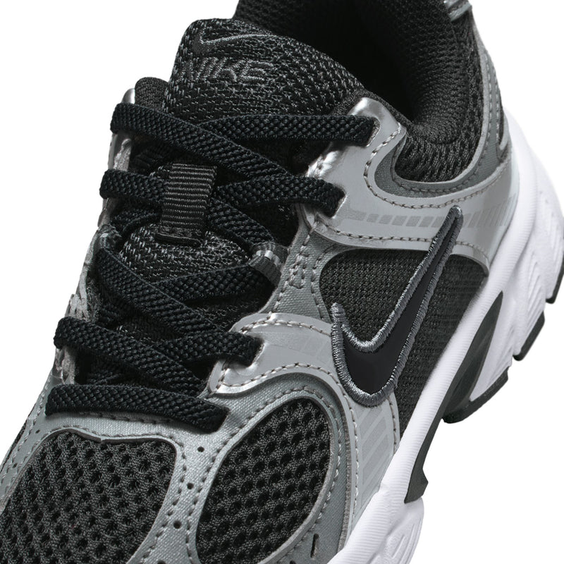 Kids sneaker close-up: black laces, silver-gray swoosh, and textured mesh upper.