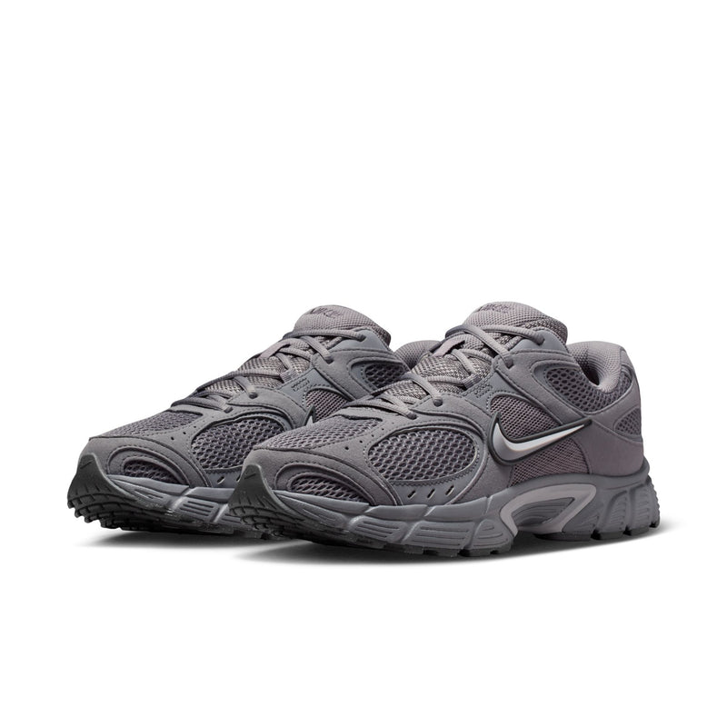 Pair of grey lace-up running shoes with mesh panels, Nike Swoosh, and thick sole.