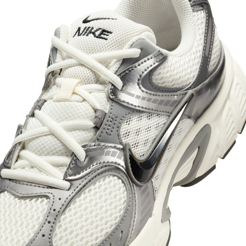 Men's athletic sneaker upper close-up, white laces, gray Swoosh, and textured mesh