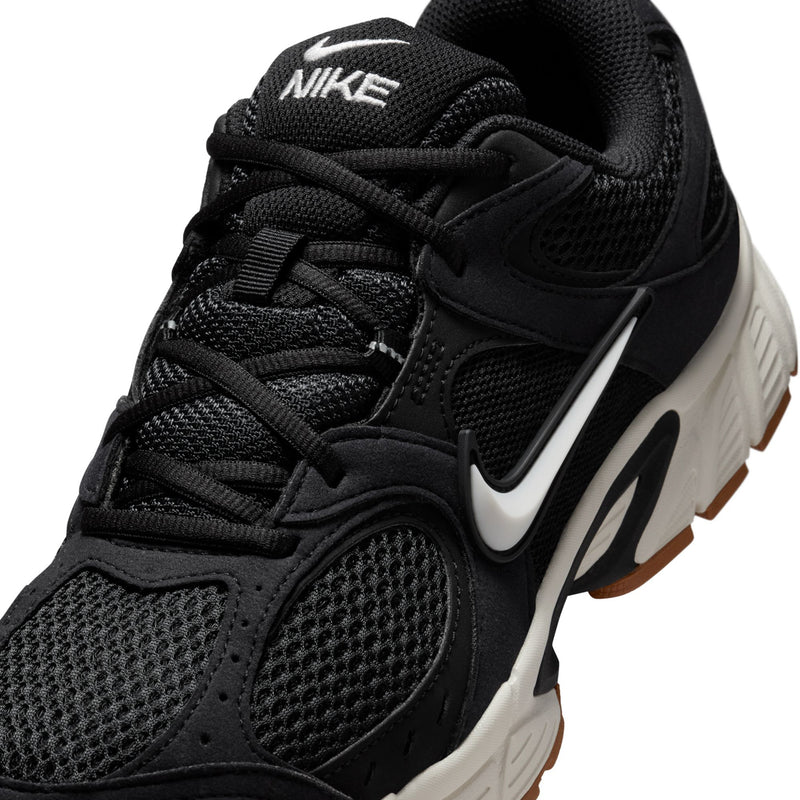 Men's black Nike running shoes close-up, mesh upper with swoosh and lace eyelets
