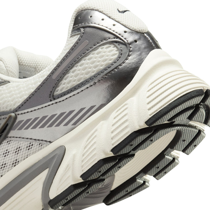 Men's athletic sneaker heel close-up with dark gray leather panel and ribbed outsole