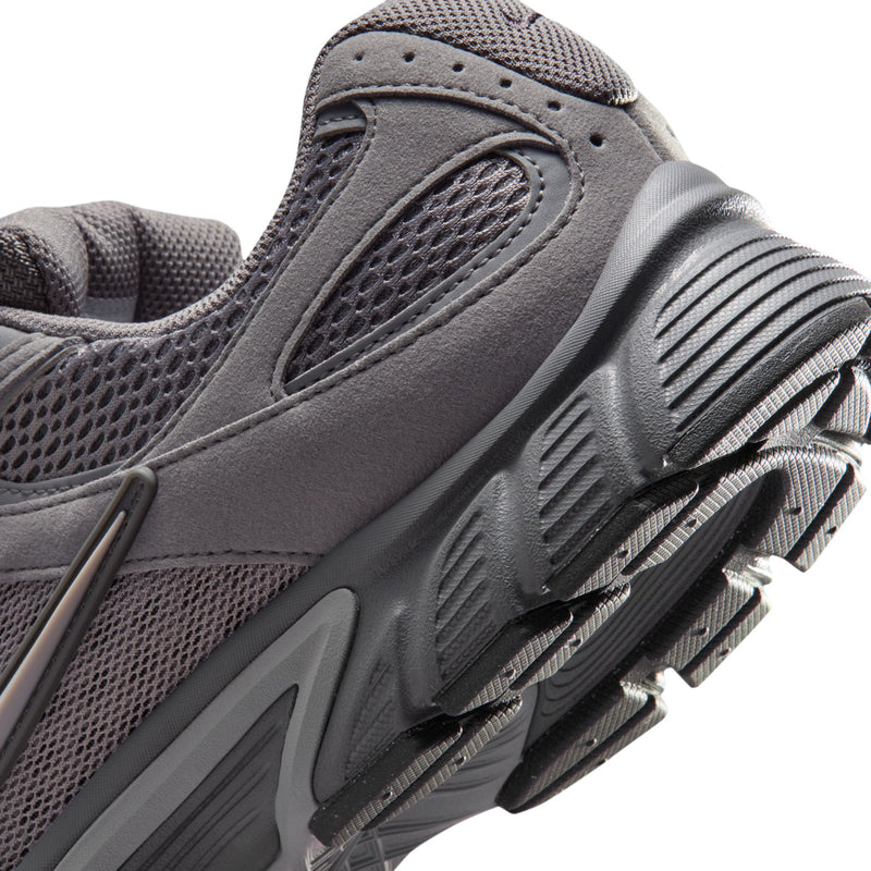 Close-up of grey running shoe side with treaded sole and textured upper details.
