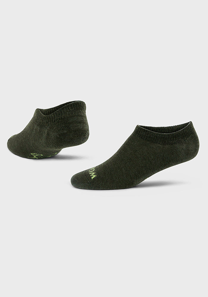 A pair of Woolx Womens Daisy Ped Socks in Leafy Green, shown on a light gray background, with one sock upright and the other on its side to highlight the ankle opening and overall design. Final Sale.