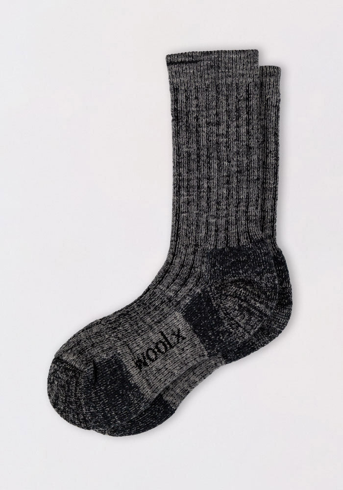 A pair of Womens Joey Crew Socks in Stone Grey by Woolx, featuring a ribbed, textured pattern, are stacked neatly on a light background. The brand name "Woolx" is visible on the sole of one cozy sock.