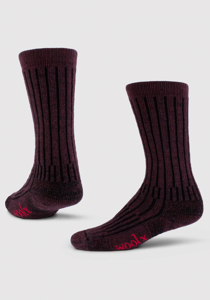 The Woolx Mens Joey Mid Calf Socks in Warm Violet feature vertical black stripes and red "woolx" text on the toe. Made from moisture-wicking Merino wool, they're shown against a plain white background.