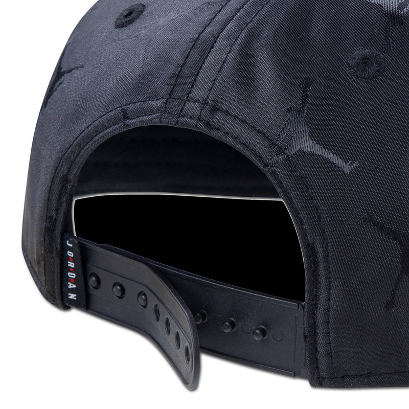 Youth black snapback cap close-up of adjustable snap strap and stitching