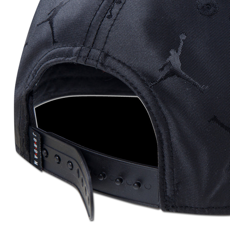 Youth black snapback cap close-up of adjustable strap with hole row